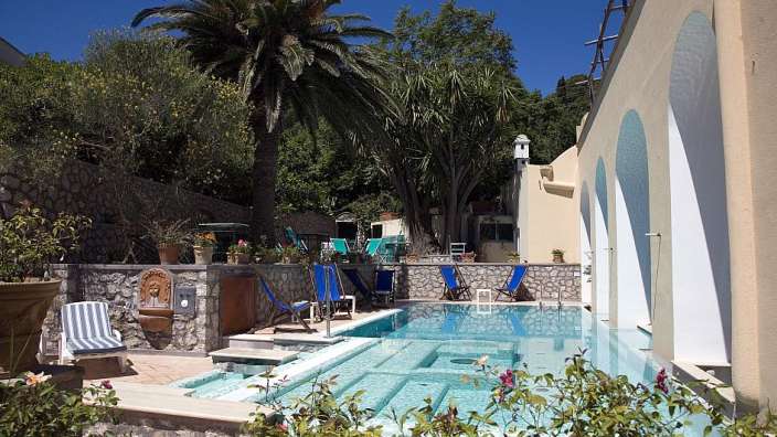 Ein großer Pool mit blauen Stühlen um ihn herum