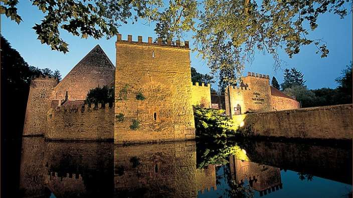 Ein altes mittelalterliches Schloss spiegelt sich im Wasser