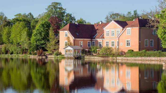 Ein großes Haus spiegelt sich in einem See