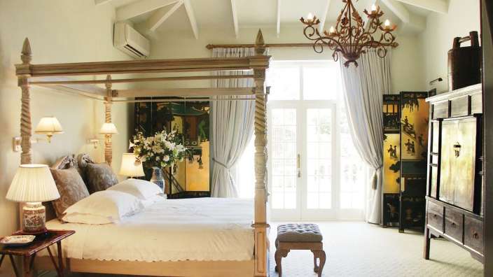 Ein Schlafzimmer mit einem Himmelbett und einem Kronleuchter