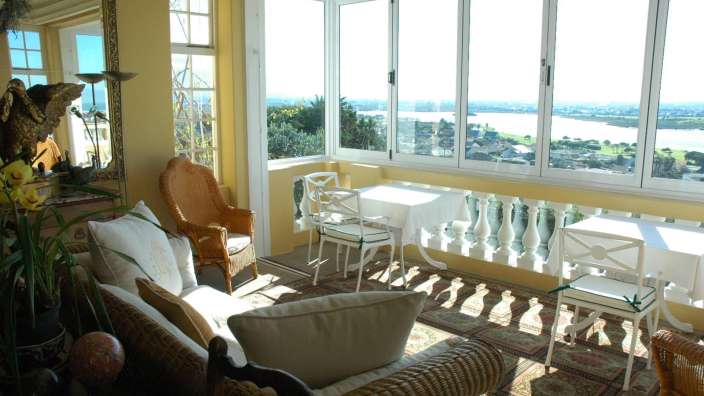 Ein Wohnzimmer mit vielen Fenstern und einem Tisch