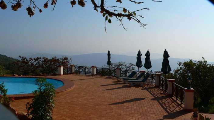 Ein Pool mit Liegestühlen und Sonnenschirmen umgeben