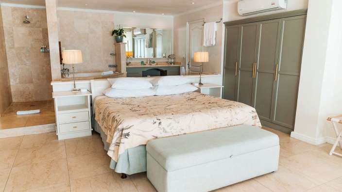 Ein Schlafzimmer mit einem Kingsize-Bett und einem Waschbecken