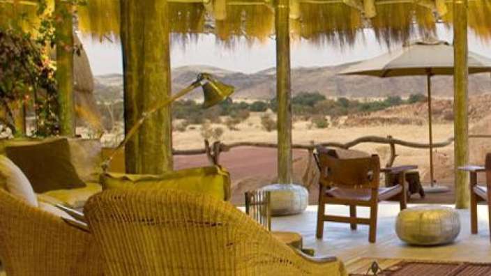 Ein Wohnzimmer mit Rattanstühlen, Stühlen und einer Lampe .