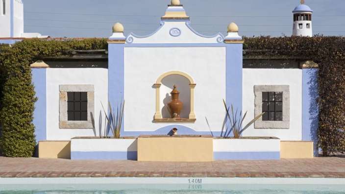 Ein weißes und blaues Gebäude mit einem Pool davor