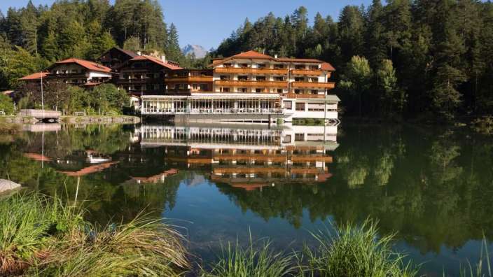 Ein großes Hotel spiegelt sich in einem See