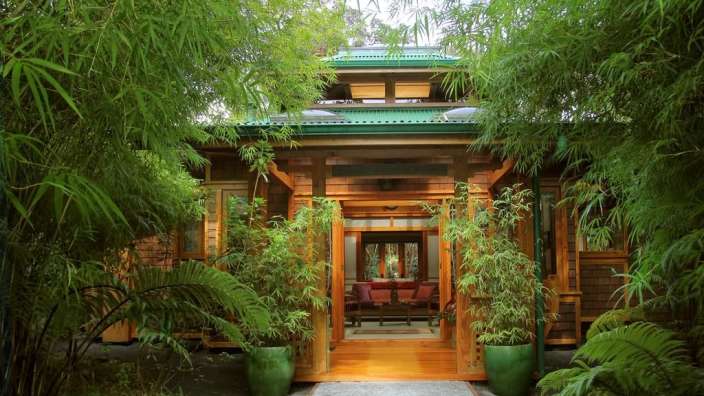 Ein Haus mit einem grünen Dach und vielen grünen Pflanzen