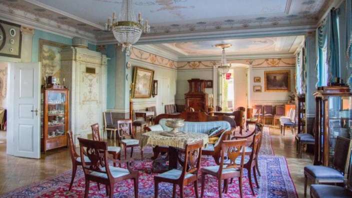 Ein großes Wohnzimmer mit einem Tisch und Stühlen