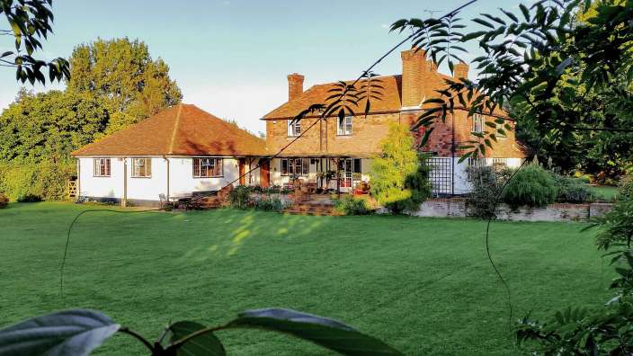 Ein großes weißes Haus mit einem roten Backsteindach