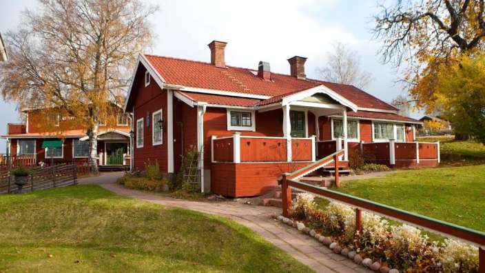 Ein rotes Haus mit weißen Fenstern und einem roten Dach