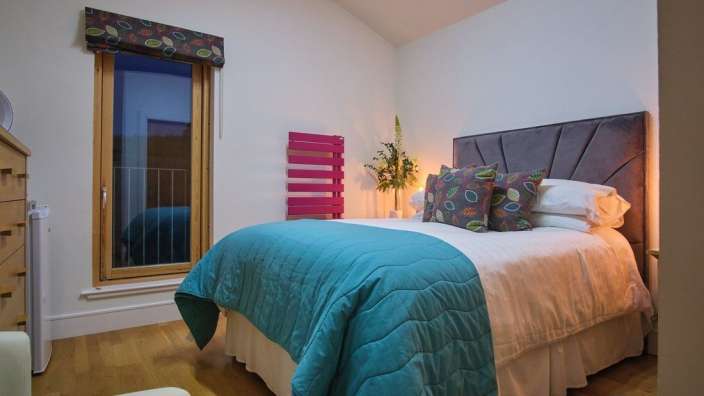 Ein Schlafzimmer mit einem Bett und einer rosa Heizung