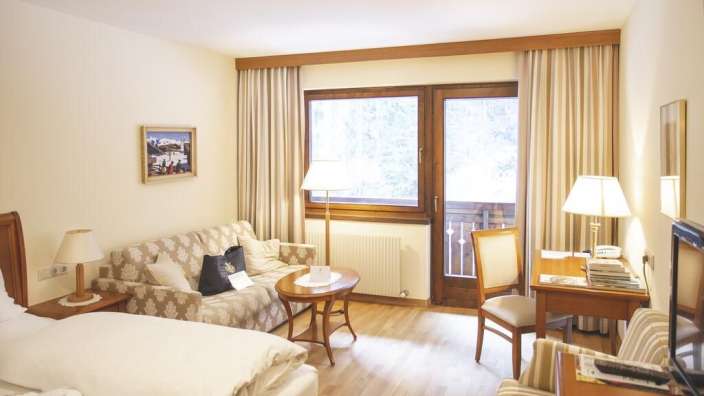 Ein Hotelzimmer mit zwei Betten und einem Schreibtisch