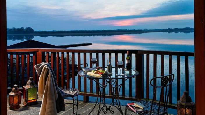 Ein Tisch und Stühle auf einem Balkon mit Blick auf einen See