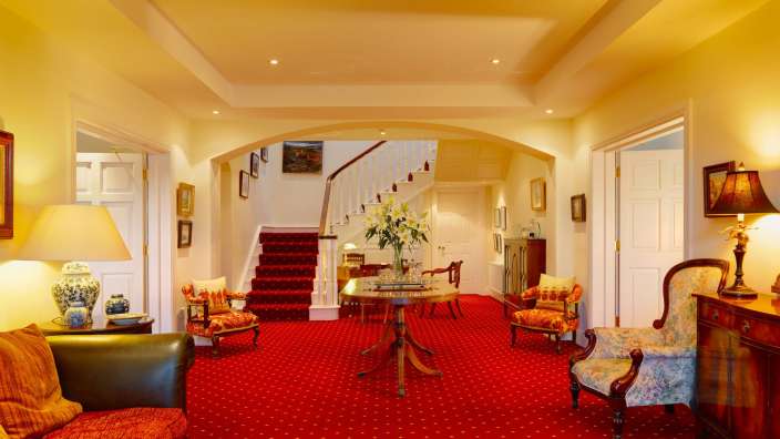 Ein Wohnzimmer mit rotem Teppich und einem Tisch