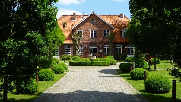 Ein Steinweg führt zu einem großen Backsteinhaus .