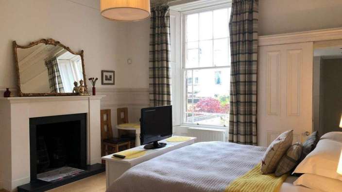 Ein Schlafzimmer mit einem Bett, einem Kamin und einem Fernseher