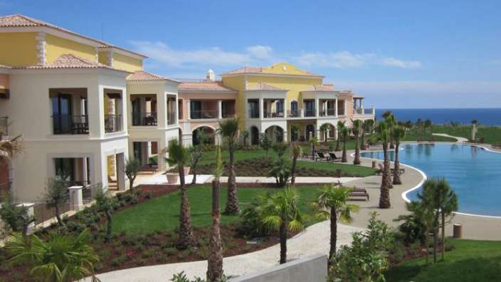 Ein großes Gebäude mit einem großen Pool im Vordergrund