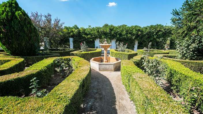 Ein labyrinthförmiger Garten mit einem Brunnen in der Mitte