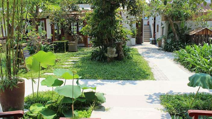 Ein Garten mit einem Tisch und Stühlen in der Mitte