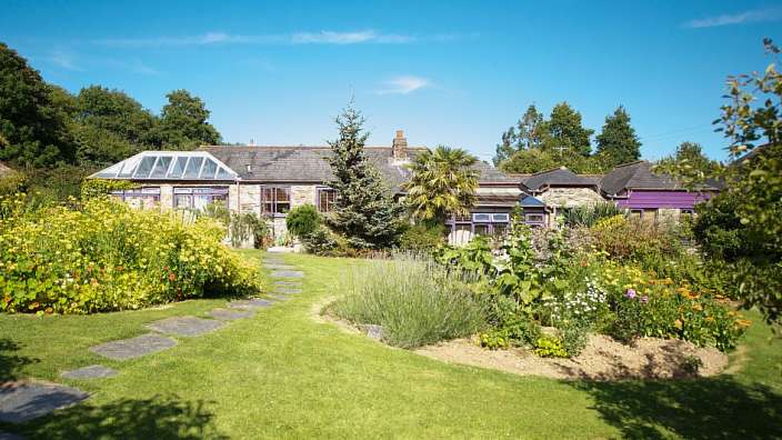 Ein garten mit einem steinweg und einem haus im hintergrund