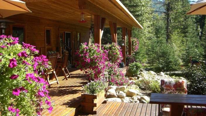 Ein Deck mit lila Blumen und einem Tisch darauf