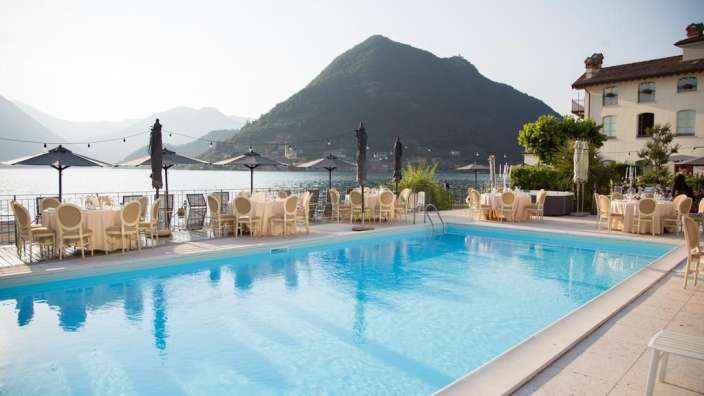 Ein großer Swimmingpool mit Tischen und Stühlen davor