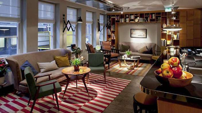 Ein Wohnzimmer mit vielen Möbeln und einem Korb mit Äpfeln