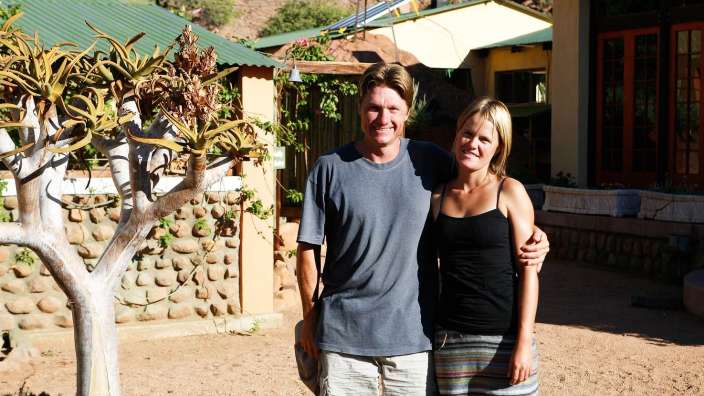 Ein Mann und eine Frau posieren für ein Foto vor einem Gebäude