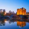 Ein altes Schloss spiegelt sich in einem Fluss