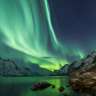 Das Nordlicht scheint über einen See in den Bergen