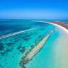 Ein weißer Strand inmitten eines türkisfarbenen Ozeans