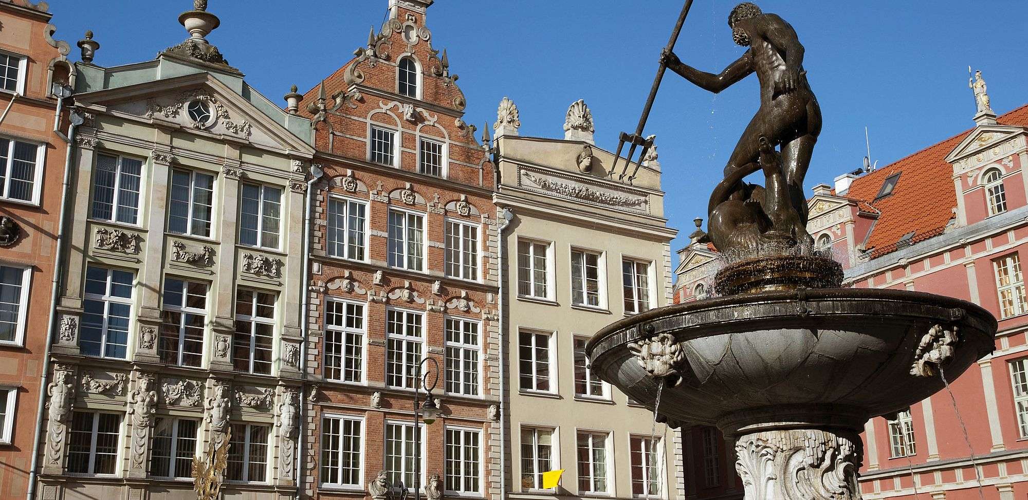 Ein Brunnen vor einem Gebäude mit einer Statue darauf