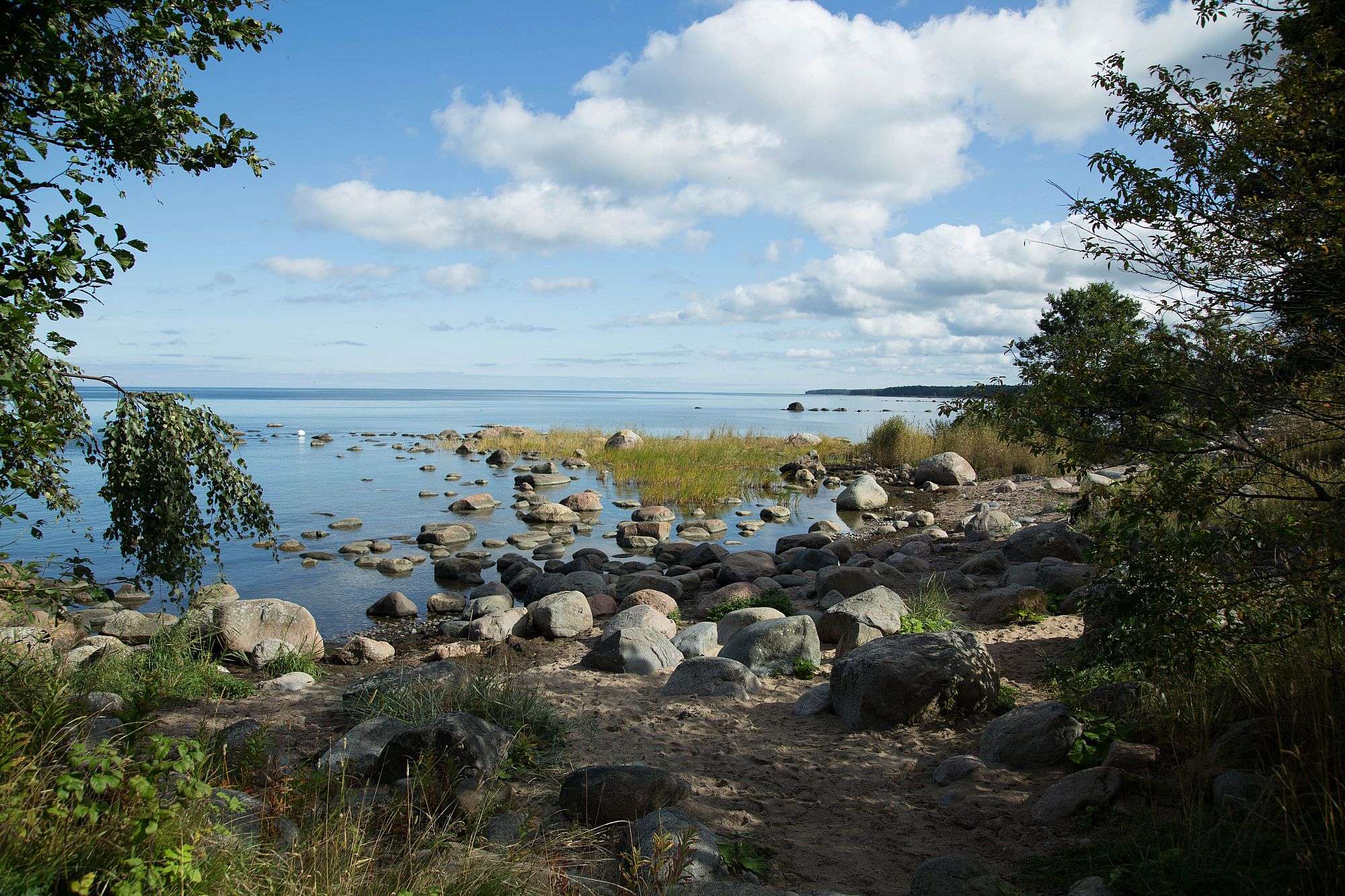 Ein felsiger Strand mit einem großen See im Hintergrund
