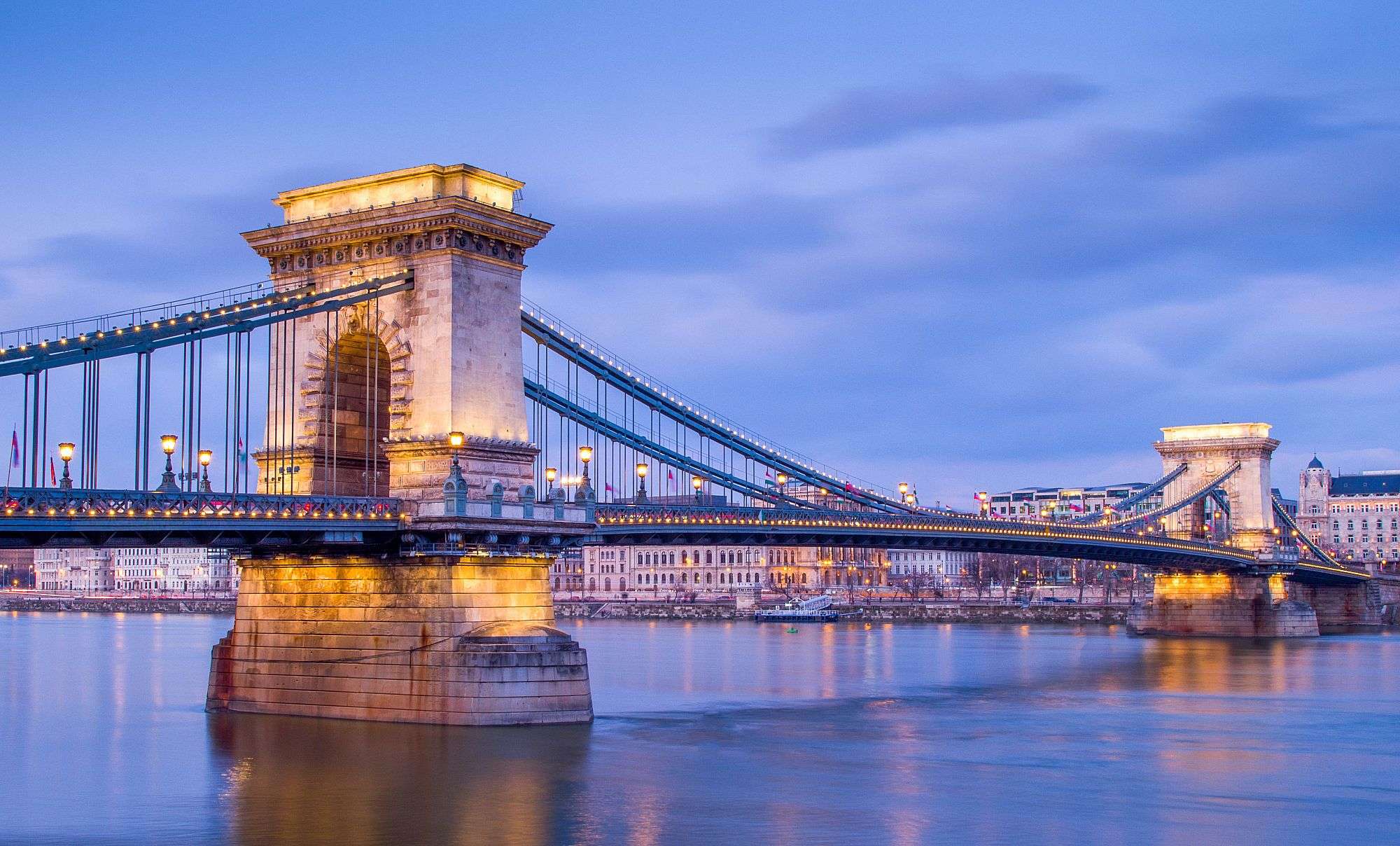 Eine Brücke über einen Fluss mit einem Gebäude im Hintergrund