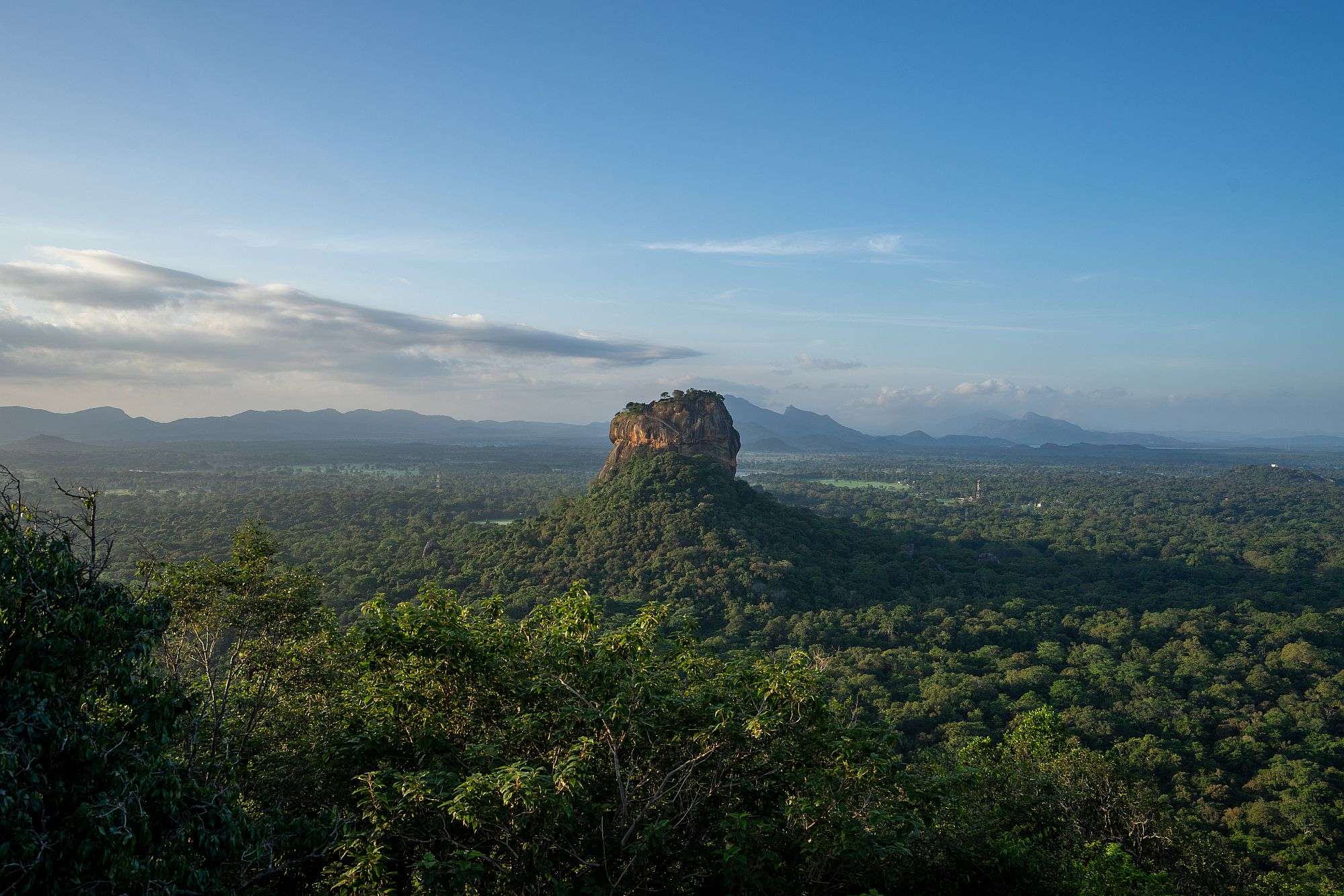 Ein großer Felsen sitzt inmitten einer grünen Landschaft