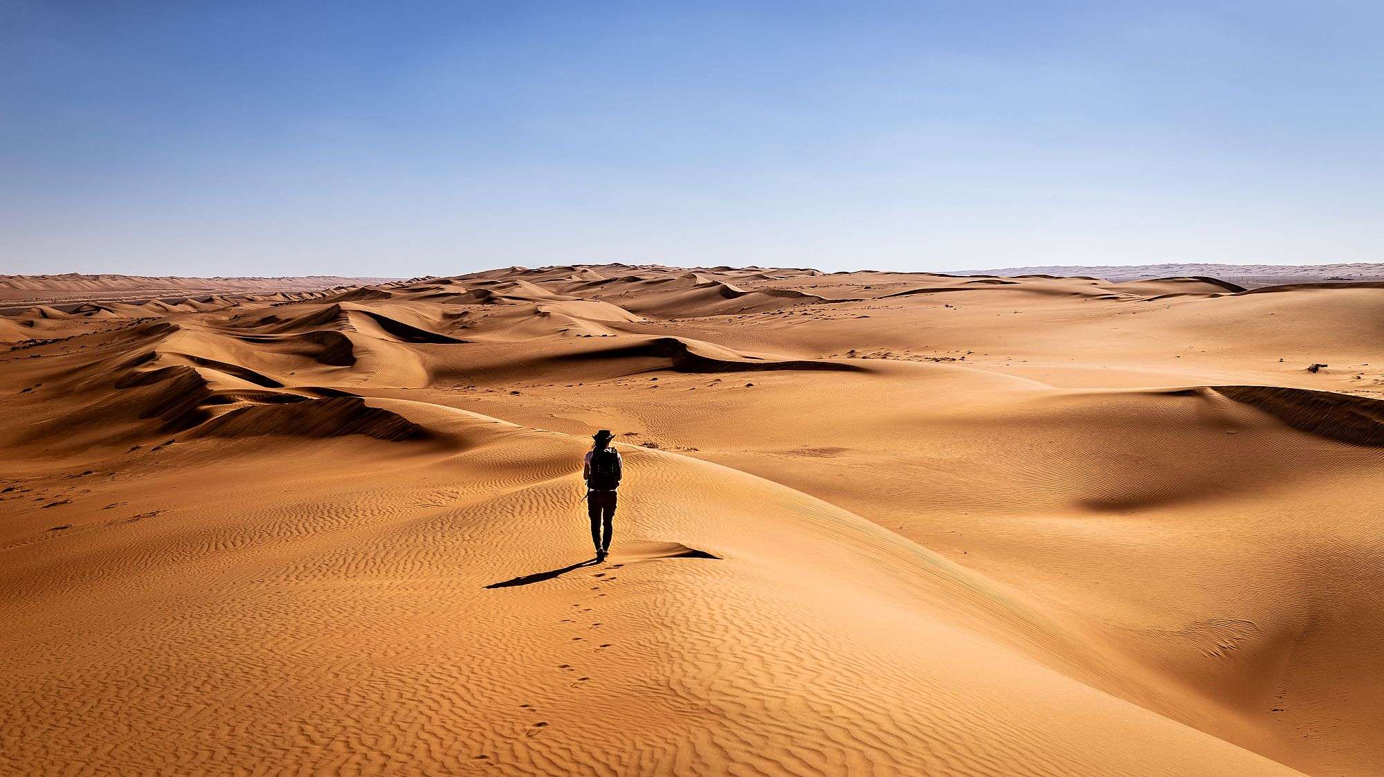 Ein Mann steht auf einer Sanddüne in der Wüste