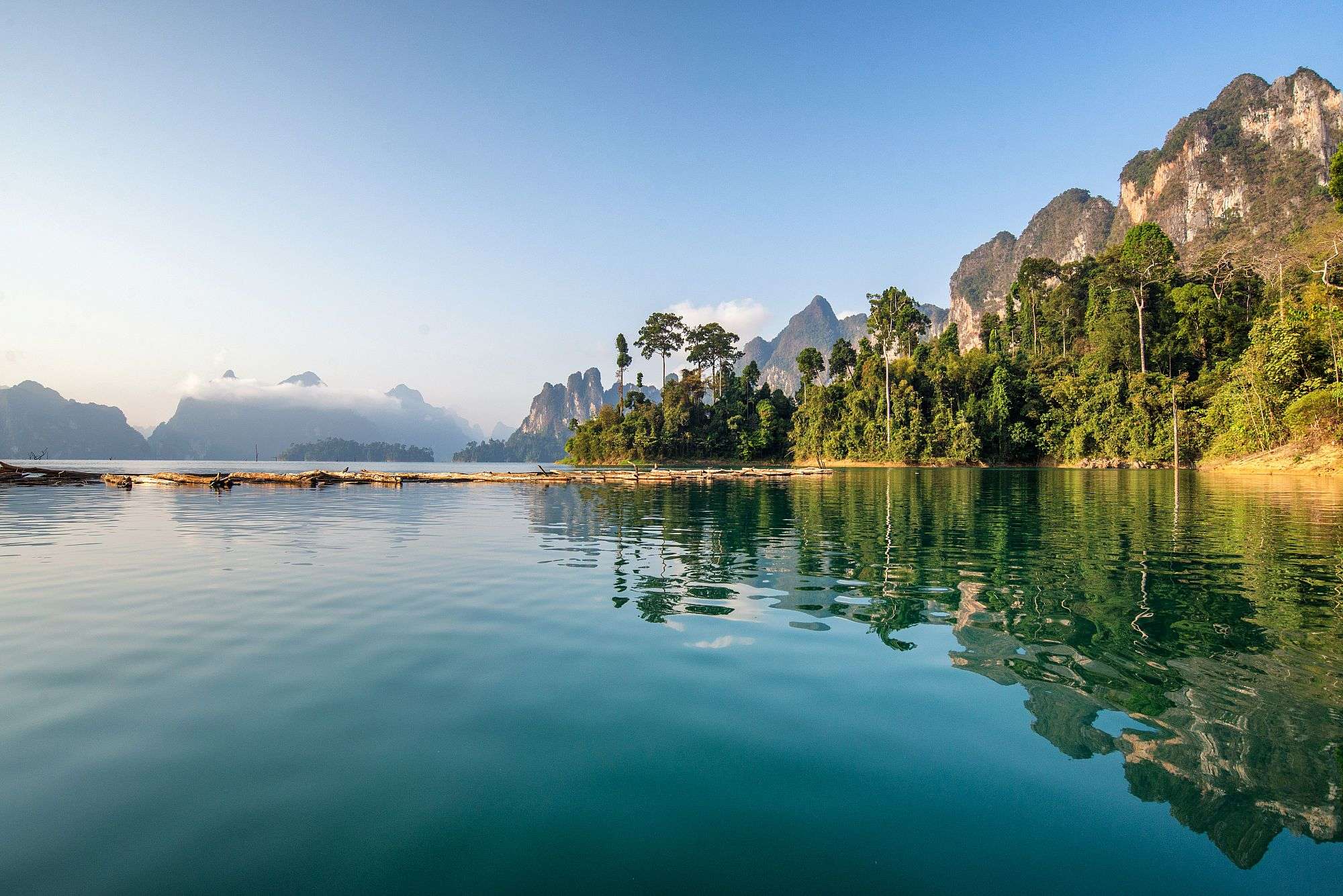 Ein See mit Bäumen und Bergen im Hintergrund